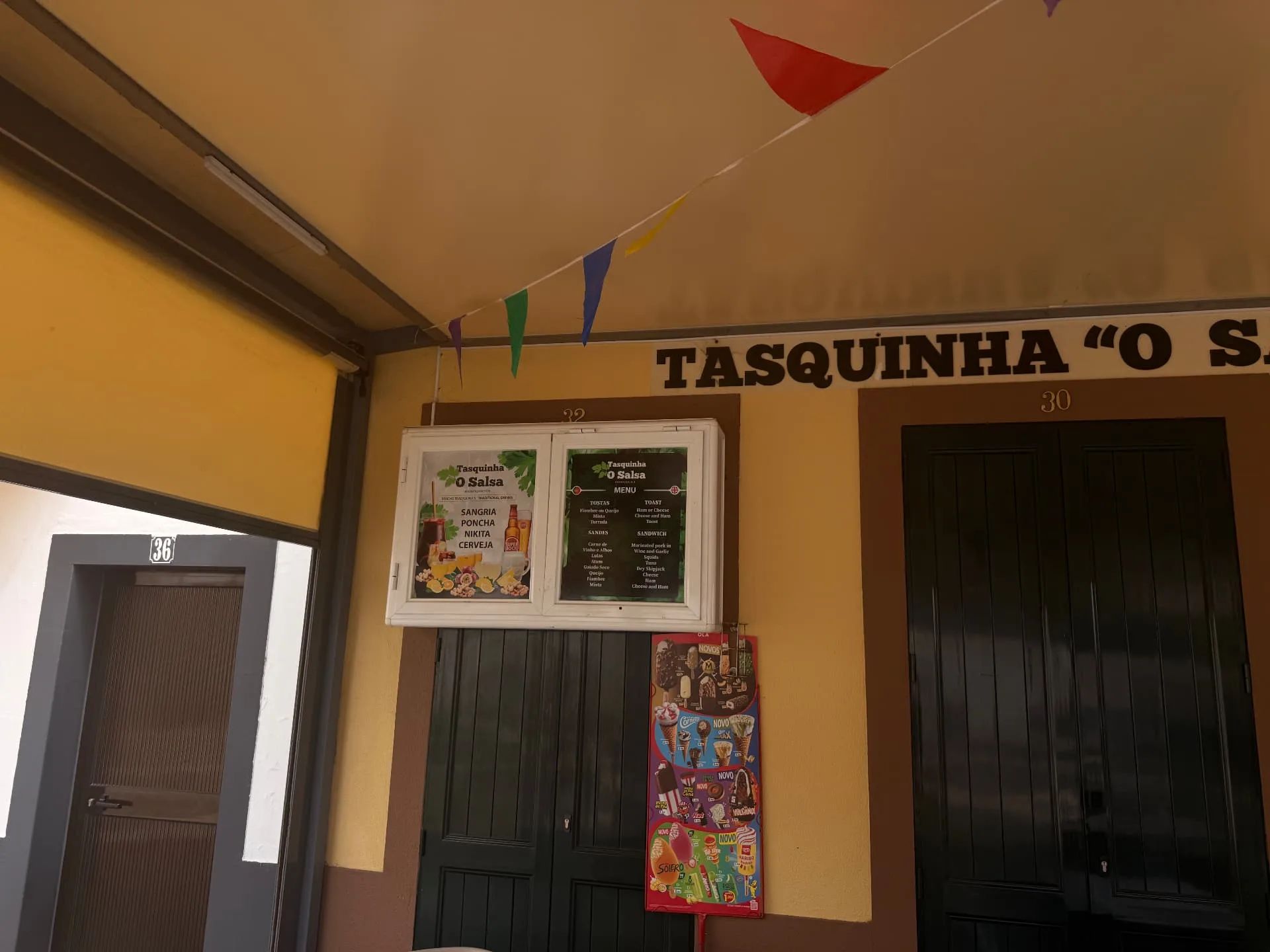 Vitrine de vidro com o menu, no exterior da Tasquinha «O Salsa», em Machico, com sangria, poncha, nikita e cerveja