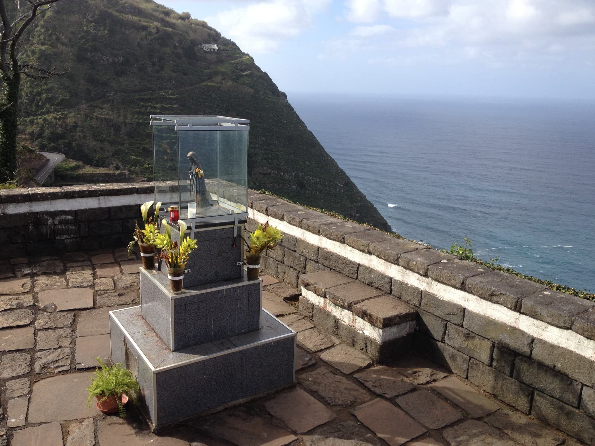 Santuário à beira da estrada e estátua num miradouro acima de Porto Moniz, na costa norte da Madeira