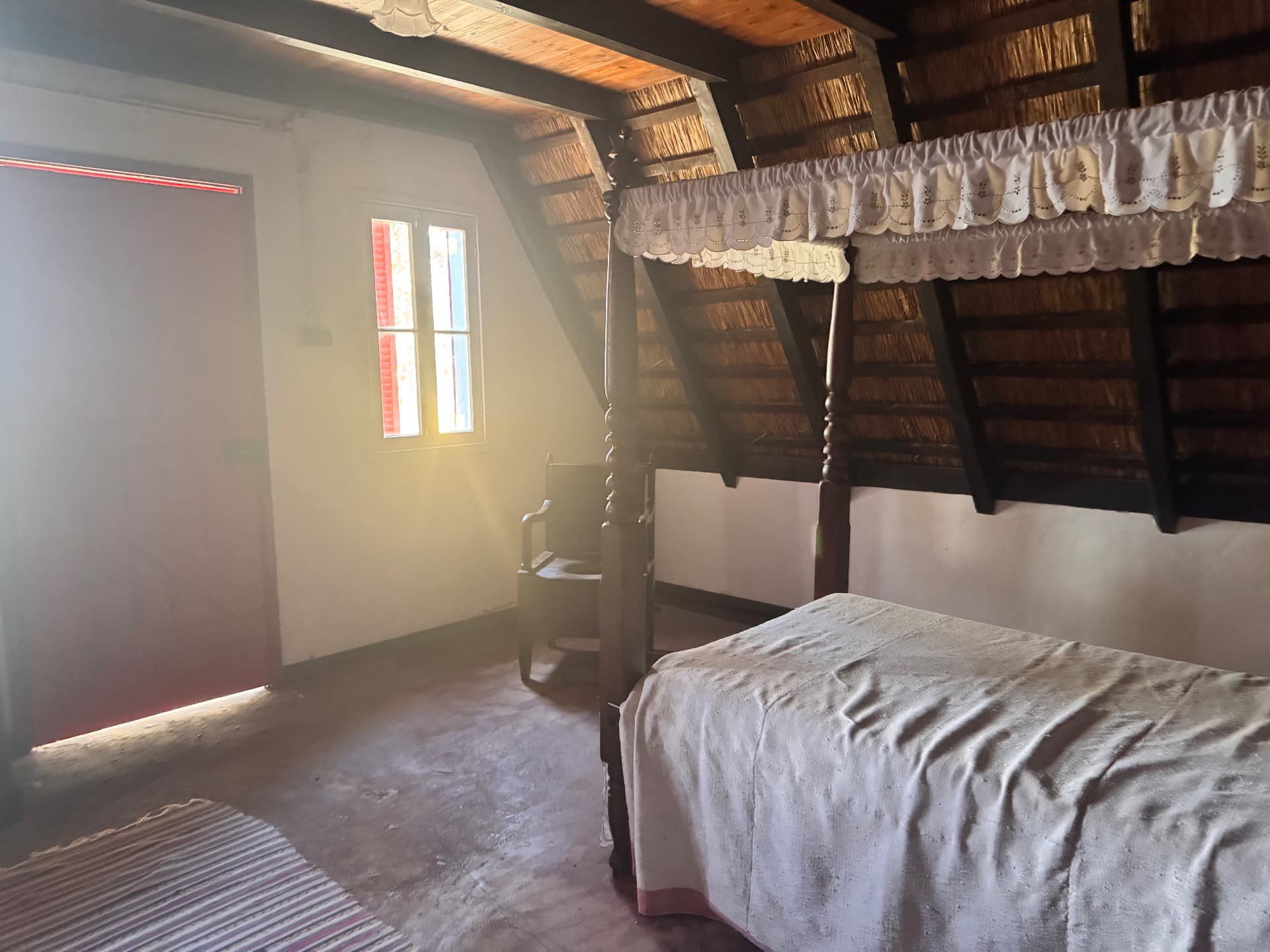 Quarto sob o telhado inclinado de colmo de uma casa tradicional de Santana, na Madeira