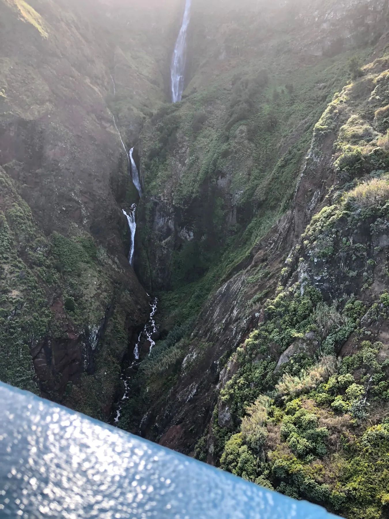 Uma alta cascata que desce para um desfiladeiro verde e íngreme perto de Santana
