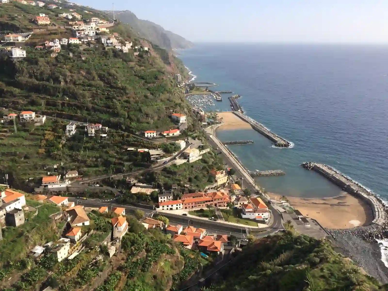 As baías arenosas da Calheta e a marina ao pé das falésias em socalcos