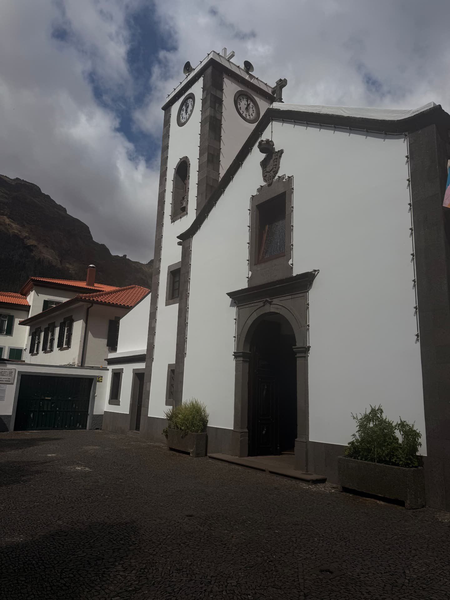 Fachada branca e torre sineira da igreja paroquial de Nossa Senhora do Livramento, Curral das Freiras
