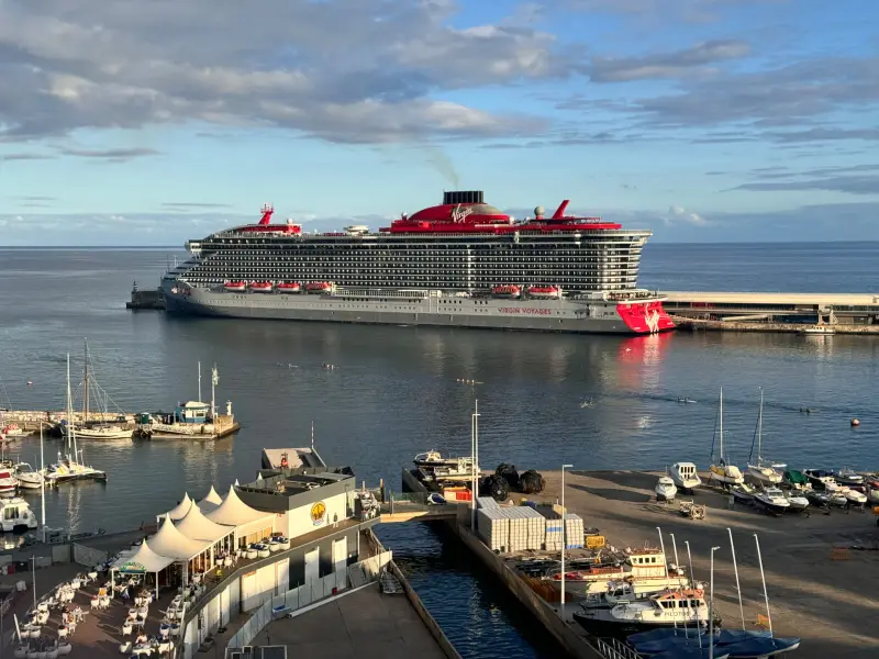 Virgin Voyages cruise ship Resilient Lady docked at Funchal cruise terminal with the marina and seafront restaurants in the foreground, Madeira