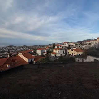 Red-tiled houses on a hillside overlooking densely built slopes and the sea
