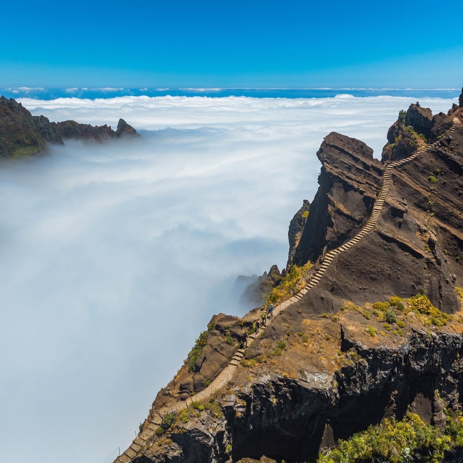 Stone staircase on the PR1 trail from Pico do Arieiro climbing a ridge above a sea of clouds, Madeira