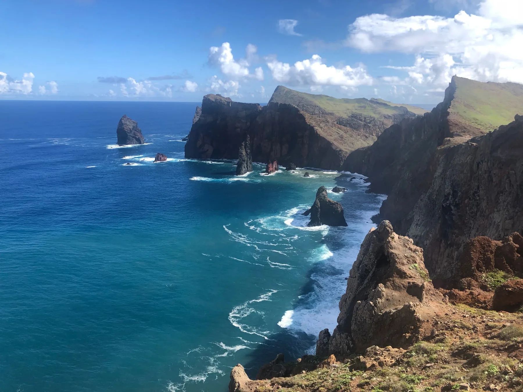Falésias escuras e o promontório verde da Ponta de São Lourenço sobre águas turquesa