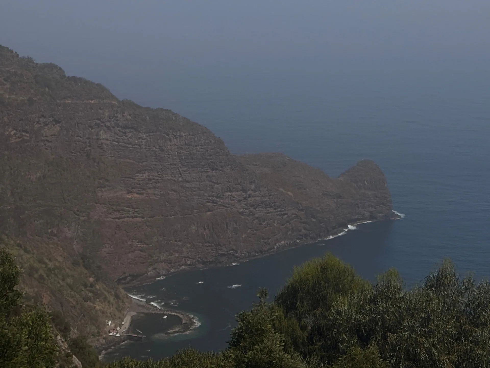 Layered volcanic cliffs around Fajã do Mar bay on the Faial coast, viewed from Miradouro do Curtado.