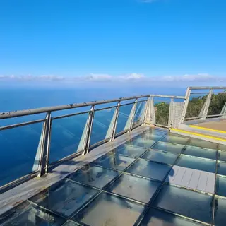 Glass floor panels of the Cabo Girão skywalk with the Atlantic 580 m below and blue sky above, Madeira