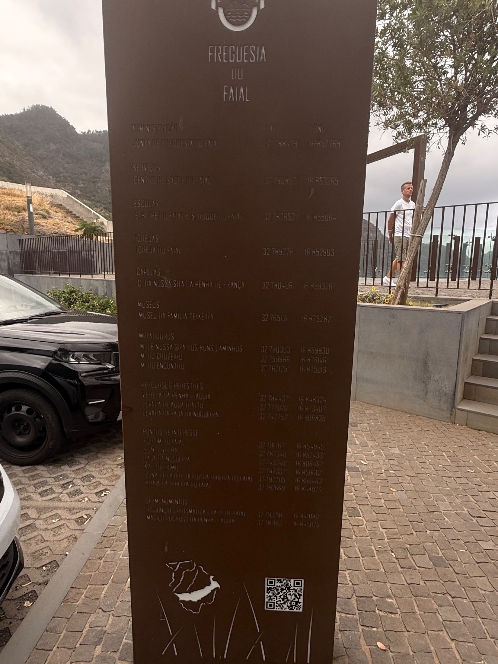 Faial parish information panel beside parked cars and steps near a coastal viewpoint