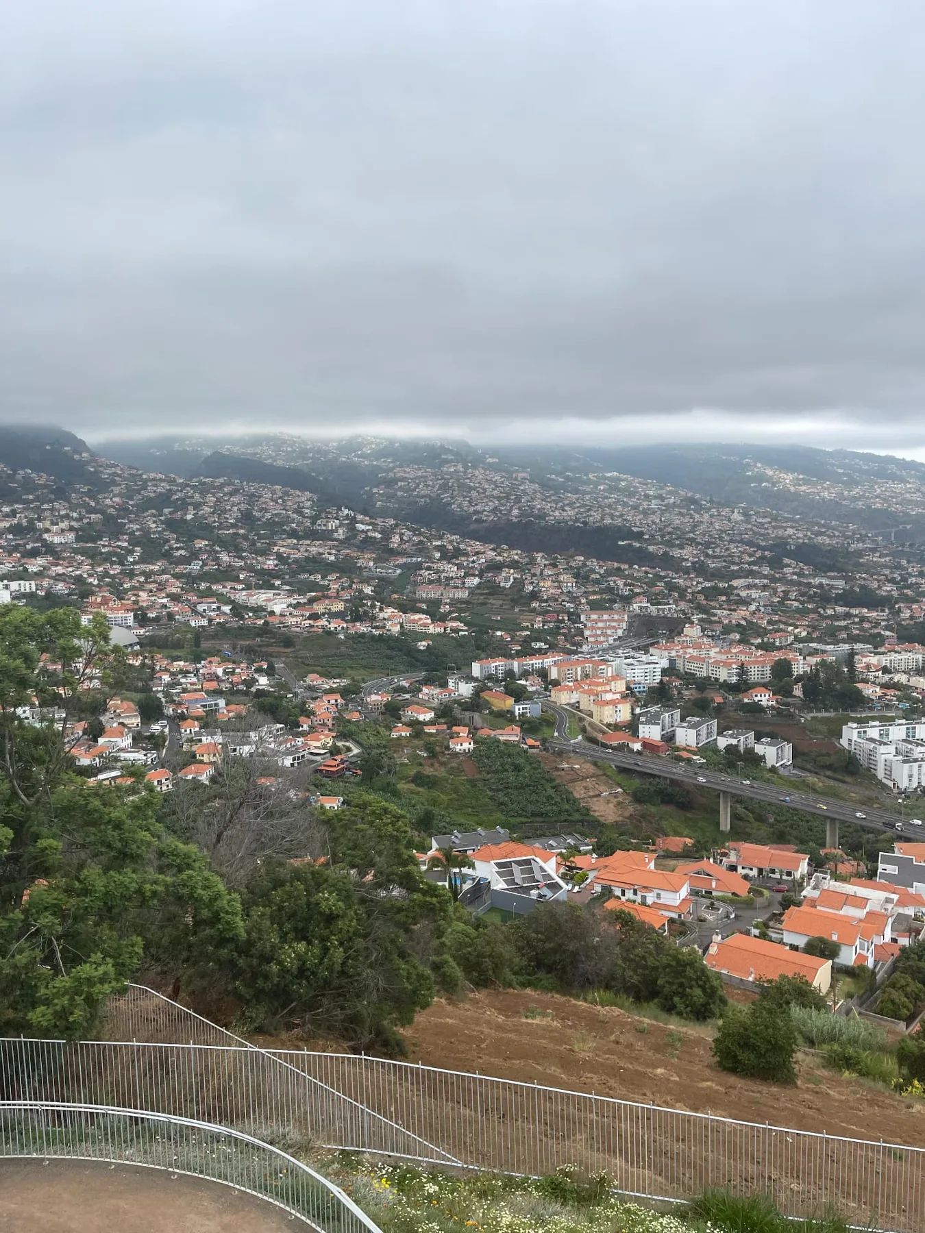View from Pico dos Barcelos over the Funchal suburbs and the motorway viaduct on a cloudy day